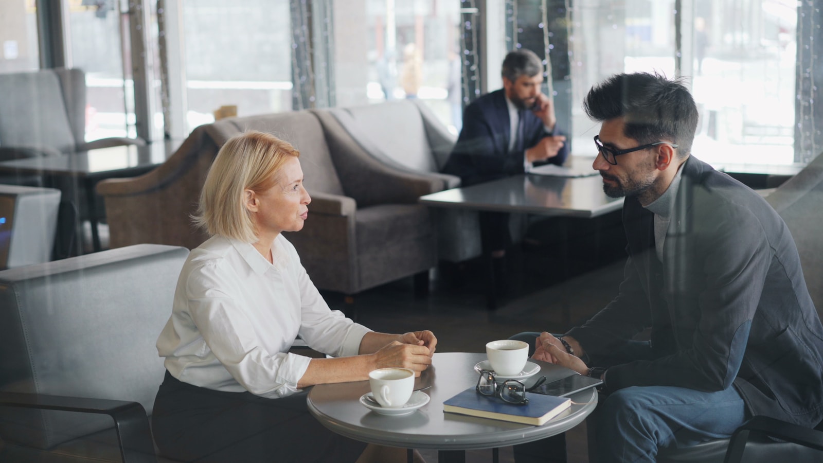 Two people having a focused conversation over coffee